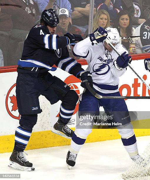 Zach Bogosian of the Winnipeg Jets and Brett Clark of the Tampa Bay Lightning collide in NHL action at the MTS Centre on April 7, 2012 in Winnipeg,...