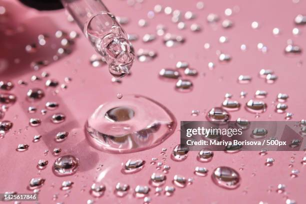 pipette,drop and splashes of micellar water on a pink background - peptídeo imagens e fotografias de stock