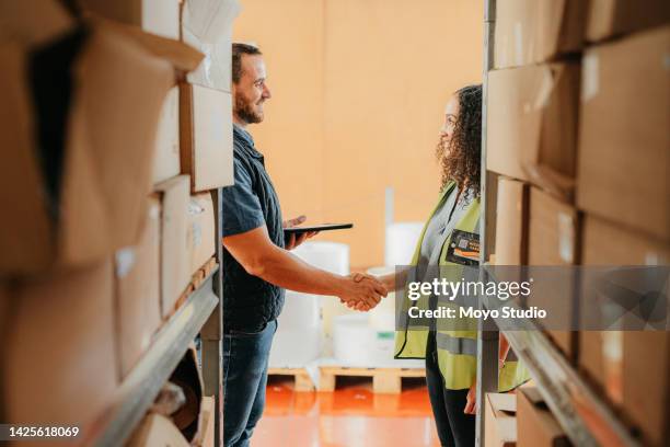 warehouse handshake, shipping deal and partnership in logistics factory, manufacturing and export industry. job buyer and supplier shaking hands for b2b agreement, meeting contract and teamwork sale - contract manufacturing stock pictures, royalty-free photos & images