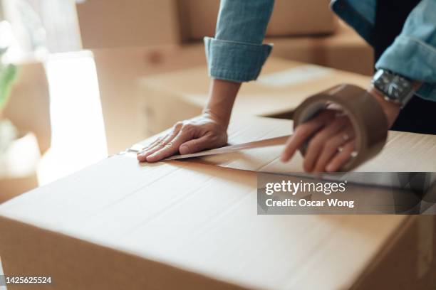 close-up of female hand packing cardboard boxes - belongings stock-fotos und bilder