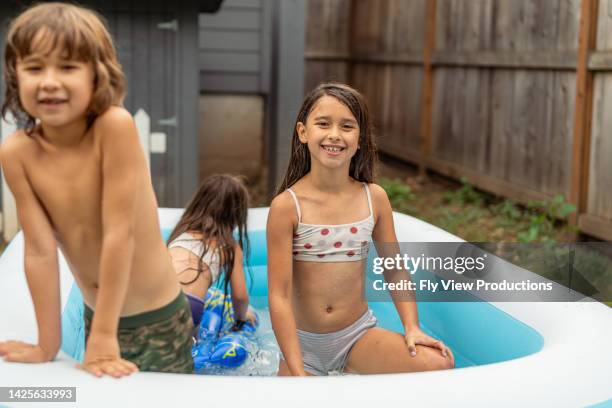 latin american children enjoying summer and sunshine in the pool! - kids swimwear stock pictures, royalty-free photos & images