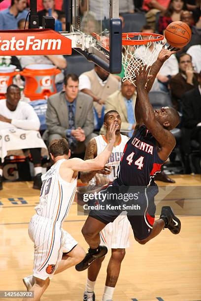 Ivan Johnson of the Atlanta Hawks shoots against Matt Carroll and Tyrus Thomas of the Charlotte Bobcats at the Time Warner Cable Arena on April 7,...