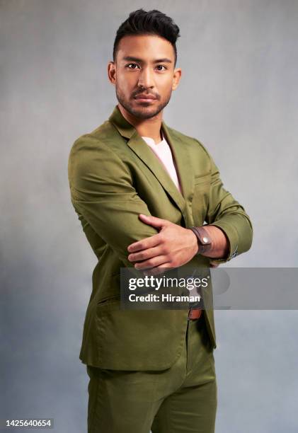 fashion, style and suit with a man model posing in studio on a gray background to be stylish, fashionable and modern. portrait of a cool and fancy young male standing arms crossed in a confident pose - tailored suit stock pictures, royalty-free photos & images