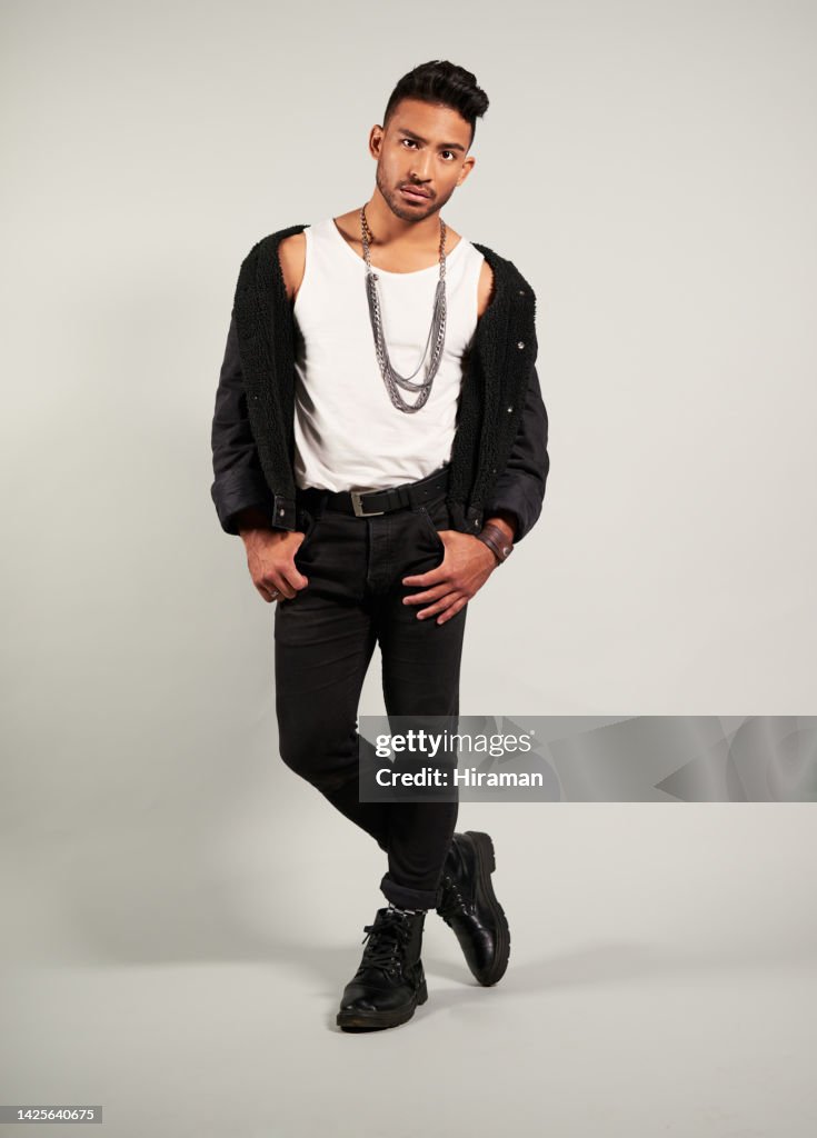 Moda, modelo y hombre de México en un estudio posando para una marca de ropa de lujo. Retrato de una generación z, aspecto duro y fresco y pose de una persona masculina joven con ropa de estilo de diseñador rico para tendencias