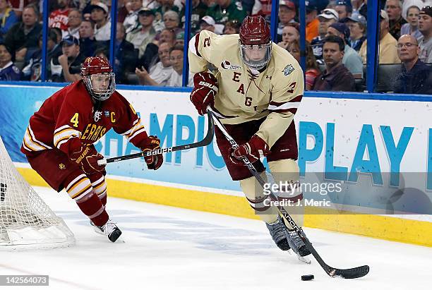 Defenseman Brian Dumoulin of the Boston College Eagles advances the puck as defenseman Chad Billins of the Ferris State Bulldogs trails during the...