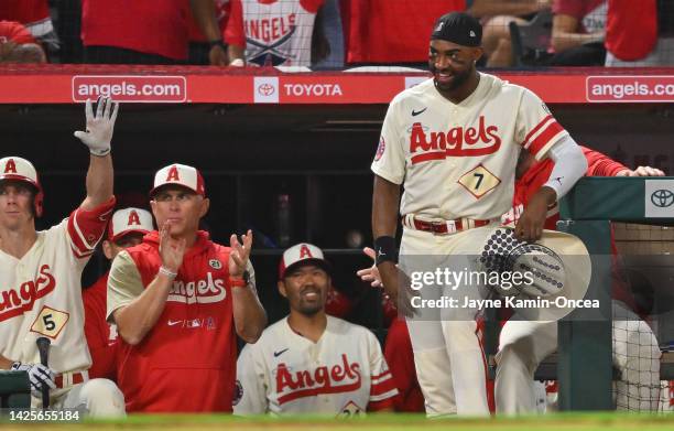 Matt Duffy , interim manager Phil Nevin, Kurt Suzuki and Jo Adell of the Los Angeles Angels wait to greet Mike Trout after a solo home run in the...