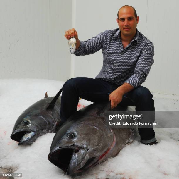 Portopalo di Capo Passero, Gabriele Scala on top of a big tuna fish in the refrigerating room of his restaurant.