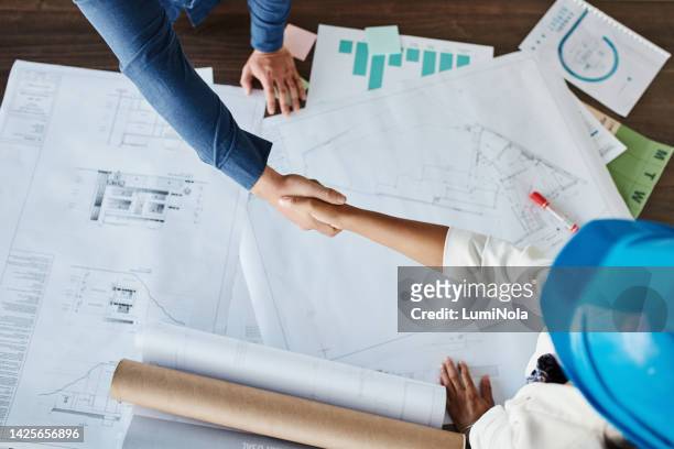 contractors shaking hands in agreement, hiring and deal in construction, architecture and engineering industry from above. team handshake success, management support and b2b meeting for building sale - consolidation stock pictures, royalty-free photos & images