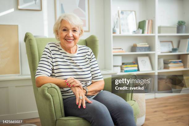 portrait of senior woman at home - alleen seniore vrouwen stockfoto's en -beelden