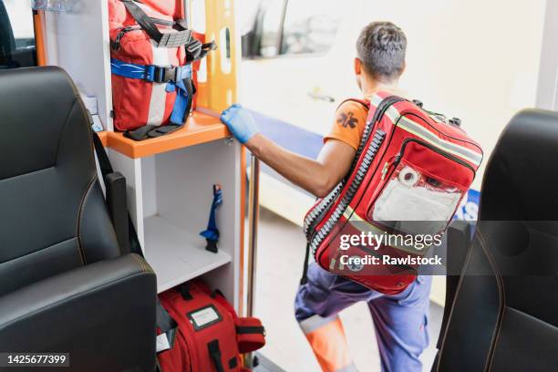 doctor with a red medical backpack getting out of an ambulance - doctor's bag stock pictures, royalty-free photos & images