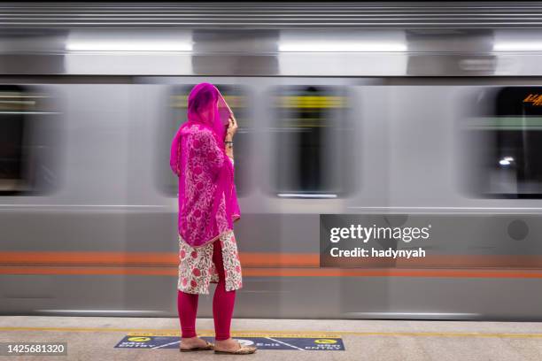 indische frau, die an der u-bahn-station auf einen zug wartet, indien - india train stock-fotos und bilder