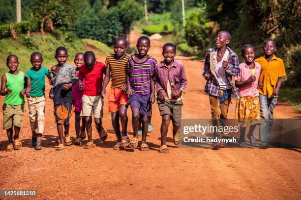 glückliche afrikanische kinder beim laufen, kenia, ostafrika - africa child stock-fotos und bilder