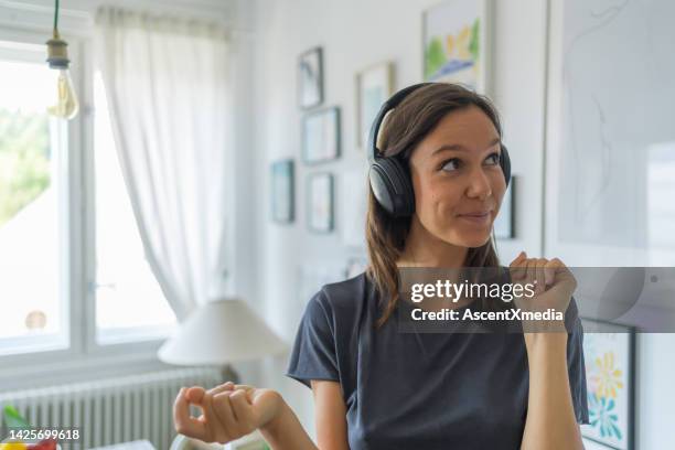 young woman listens to music on headphones, dances - clicking fingers stock pictures, royalty-free photos & images