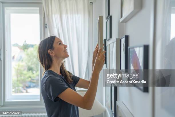 mujer joven pone imagen en la pared de la sala de estar - video wall fotografías e imágenes de stock