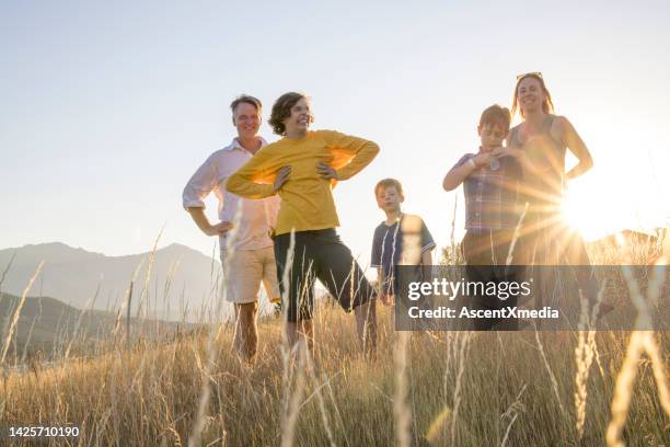 young family in mountain meadow at sunset - portrait of a woman 40 50 summer stock pictures, royalty-free photos & images