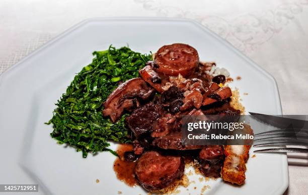 viewed from above. dish served with brazilian feijoada, black beans ,  pork, and their side dishes. - brazilian feijoada dish stock-fotos und bilder