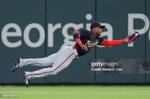 Victor Robles of the Washington Nationals dives to catch this line drive by Travis d'Arnaud of the Atlanta Braves to end the sixth inning at Truist...
