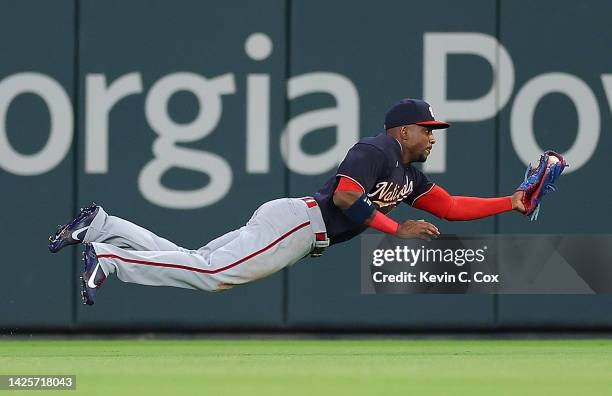 Victor Robles of the Washington Nationals dives to catch this line drive by Travis d'Arnaud of the Atlanta Braves to end the sixth inning at Truist...