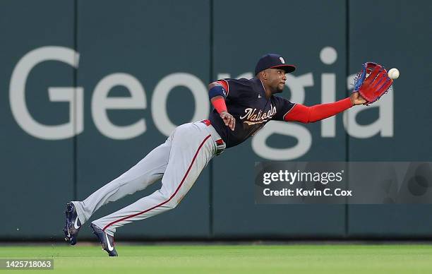 Victor Robles of the Washington Nationals dives to catch this line drive by Travis d'Arnaud of the Atlanta Braves to end the sixth inning at Truist...