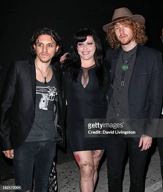 Model Mia Tyler poses with Click Clack Boom band members Jesse Kotansky and Nathaniel Hoho at the band's performance presented by Andrew Charles and...