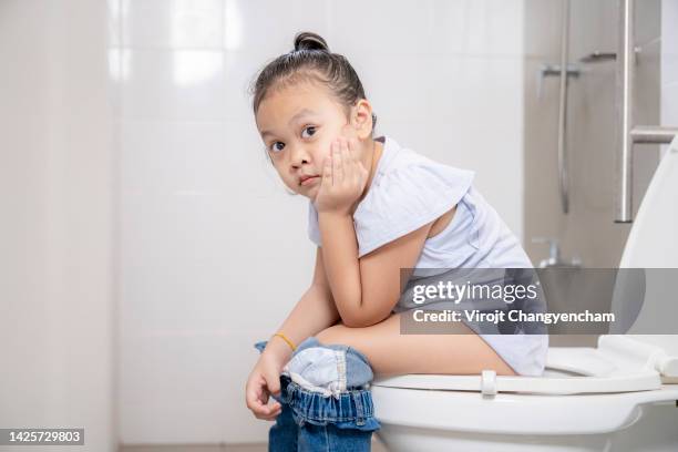 young girl sitting on the toilet - girls peeing stock pictures, royalty-free photos & images