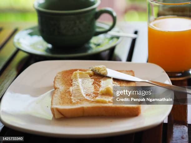 buttered bread on white plate - toastbrot stock-fotos und bilder