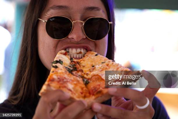 Kelsie Whitmore of the Staten Island Ferryhawks eats a slice of pizza at the San Gennaro Feast in Little Italy on September 19, 2022 in New York...