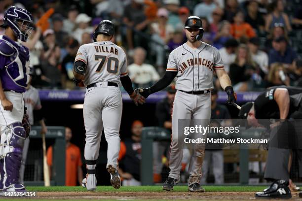 David Villar of the San Francisco Giants is congratulated by Joey Bart as he heads into the dugout after hitting a solo home run against the Colorado...