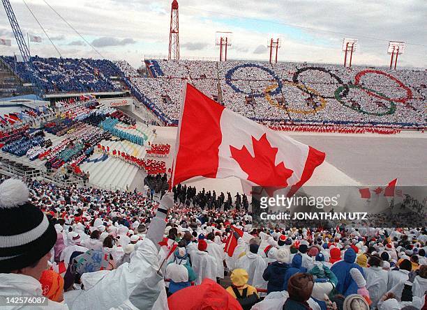 Fans cheer and wave flags as the Canadian delegation parades during the opening ceremony of the XVth Winter Olympic Games 13 February 1988 in...