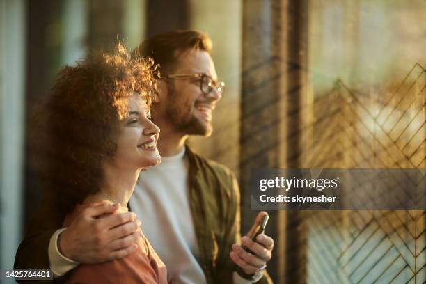 happy couple in love in a hallway. - couple looking through window stock pictures, royalty-free photos & images