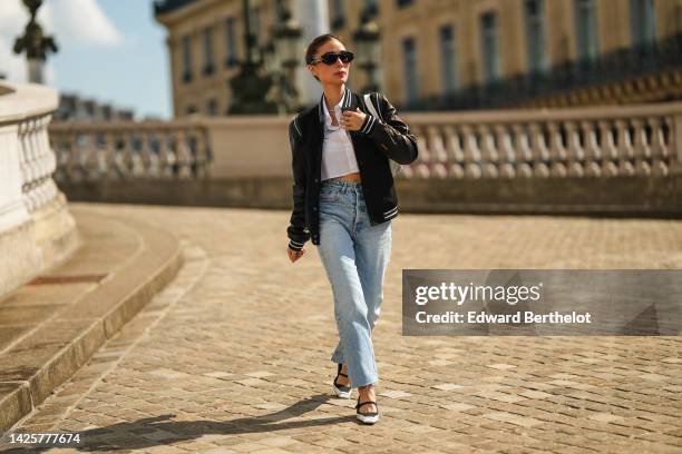 Heart Evangelista wears black sunglasses from Dior, diamonds earrings, a white cropped shirt, a diamonds necklace, a black felt with black leather...