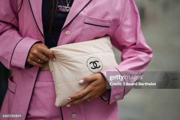 Gabriella Berdugo wears gold chain pendant necklaces, a black cropped tank-top, a pink shiny leather jacket, matching pink shiny leather pants, a...