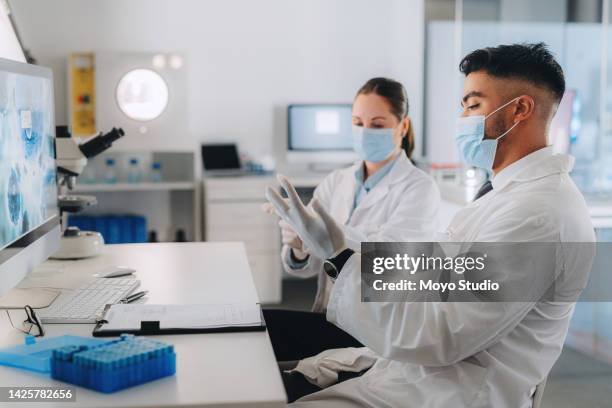 medical scientist with mask and covid or bacteria research in a laboratory with a computer. science expert or doctor working on a corona vaccine analysis with digital technology in a healthcare lab - asking time stock pictures, royalty-free photos & images