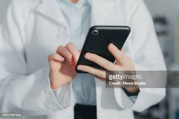 lab woman, smartphone and reading health news online for personal evaluation and analysis. medical worker expert in science chemistry looking at alternative healthcare opinion on internet. - doctor publication stock pictures, royalty-free photos & images