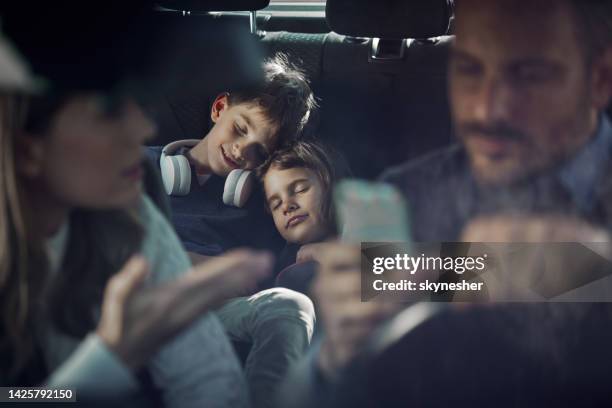 small kids taking a nap during family trip by car. - sleeping in car stockfoto's en -beelden