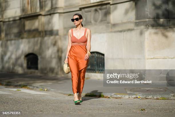 Julia Comil wears black sunglasses from Lanvin, blue and green earrings, a half golf chain and half white pearls necklace from Reliquia, an orange...