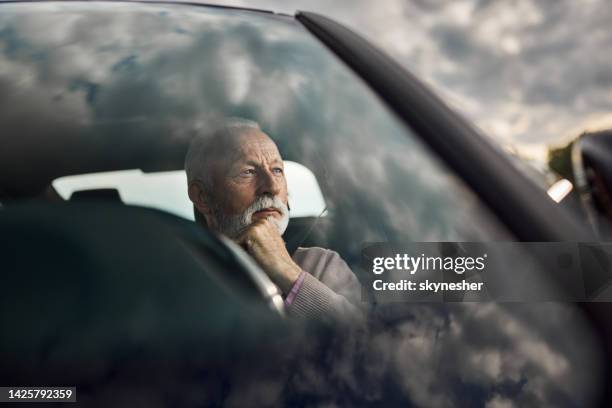 thoughtful senior man in a car. - car reflection window stock pictures, royalty-free photos & images
