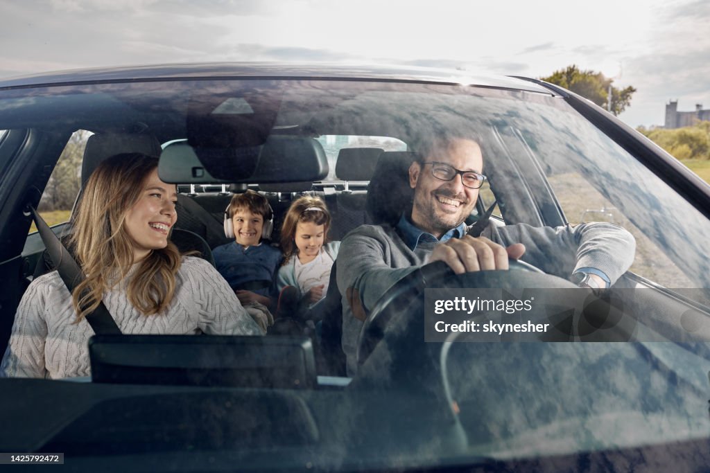 Happy family enjoying while going on a vacation by car.