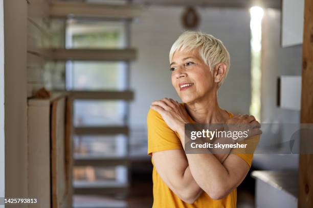 happy senior woman day dreaming at home. - krama sig själv bildbanksfoton och bilder