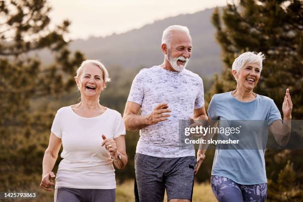 happy senior athletes running during sports training in nature. - senior people training imagens e fotografias de stock