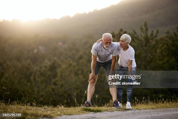 tired senior couple resting after sports training in nature. - senior people training imagens e fotografias de stock