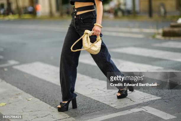 Julia Comil wears a black denim short sleeves / cropped shirt from Jacquemus, black denim Y2K 2000s Cut out waistband sustainable from A Golde, a...