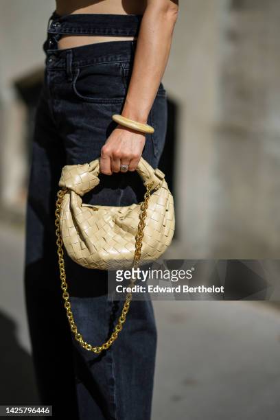 Julia Comil wears black denim Y2K 2000s Cut out waistband sustainable from A Golde, a beige large bracelet, a silver watch from Cartier, a ring, a...