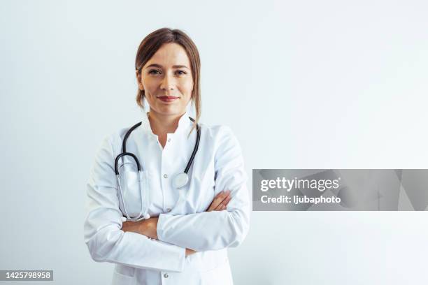 photo of confident female doctor in hospital, looking at camera with smile. - vrouwelijke dokter stockfoto's en -beelden