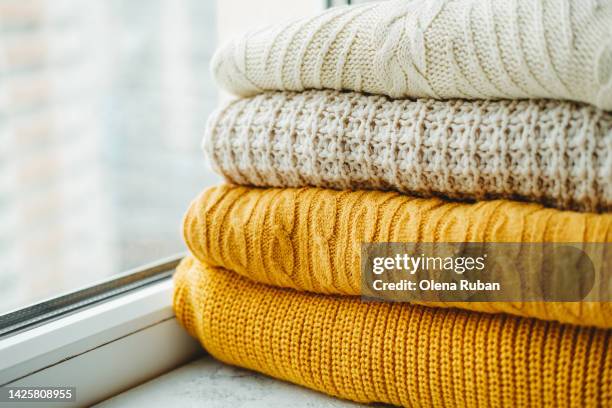 knitted sweaters lying on windowsill. - thick stock pictures, royalty-free photos & images