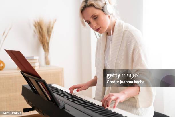 professional female musician composing music, writing sheet music. - electric piano stock pictures, royalty-free photos & images