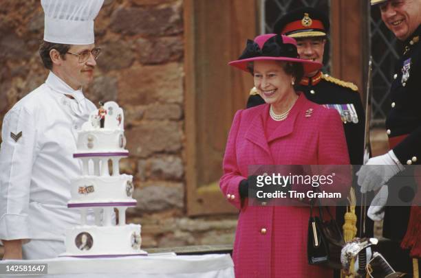 Queen Elizabeth II is presented with a birthday cake by the men of the Royal Welch Fusiliers, during a visit to Powis Castle in Wales, 21st April...