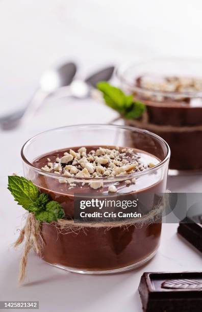 two glasses of chocolate pudding with nuts - vanillesoße stock-fotos und bilder