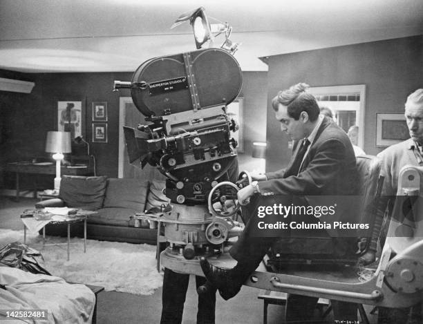 American director and screenwriter Stanley Kubrick on a camera dolly on the set of his film 'Dr. Strangelove or: How I Learned to Stop Worrying and...