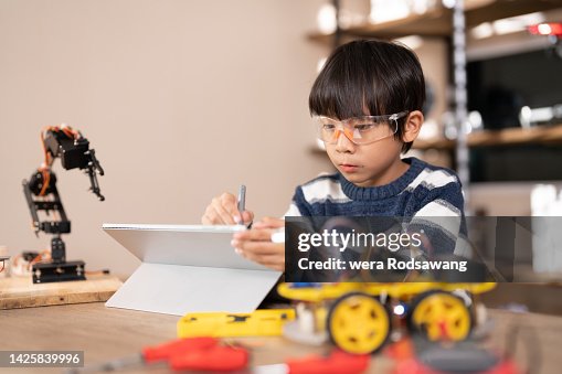A boy practice build robots use software to code and program A boy practice build robots use software to code and program